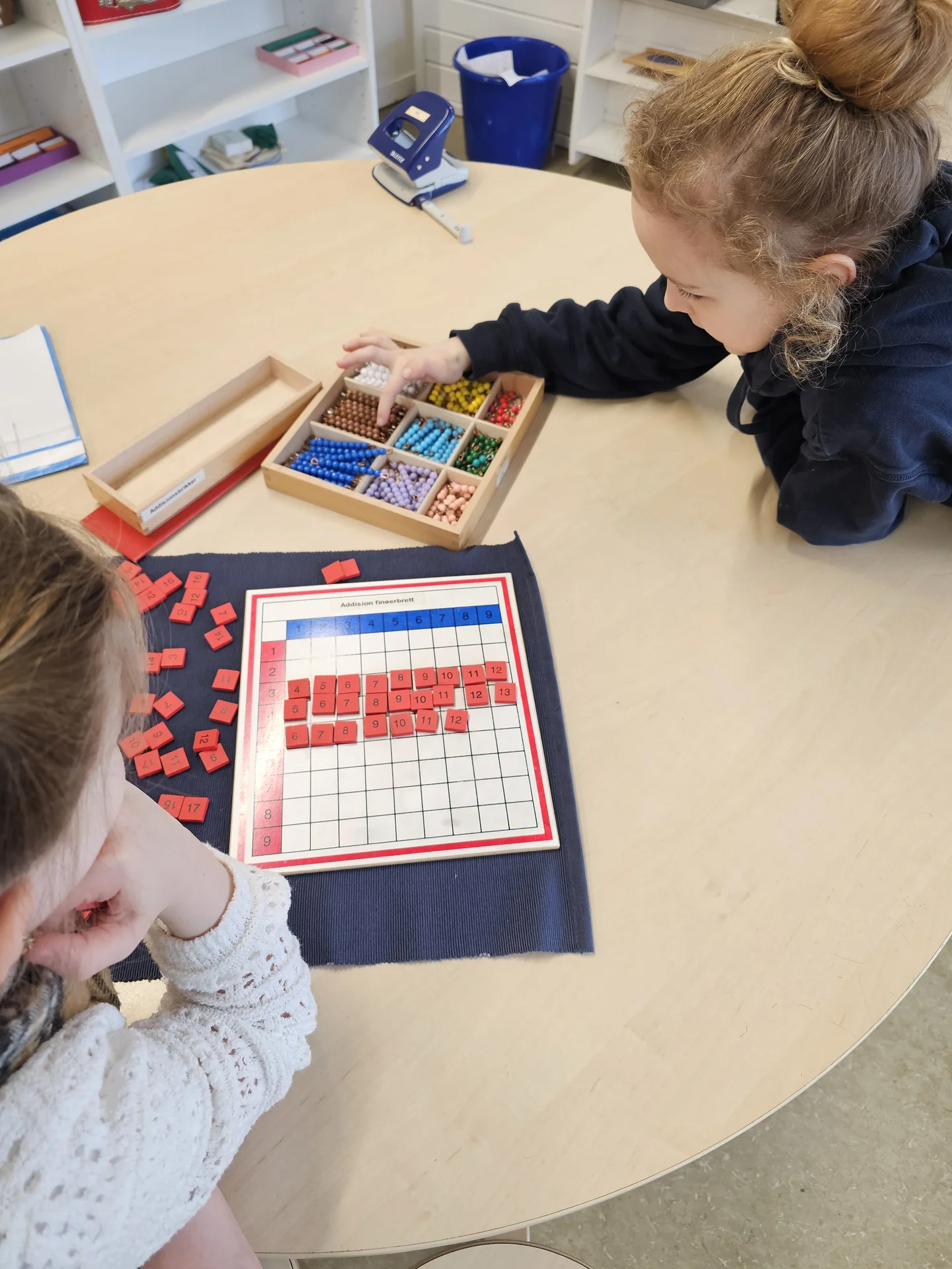 Elevar som arbeider med multiplikasjonsbrett og perler