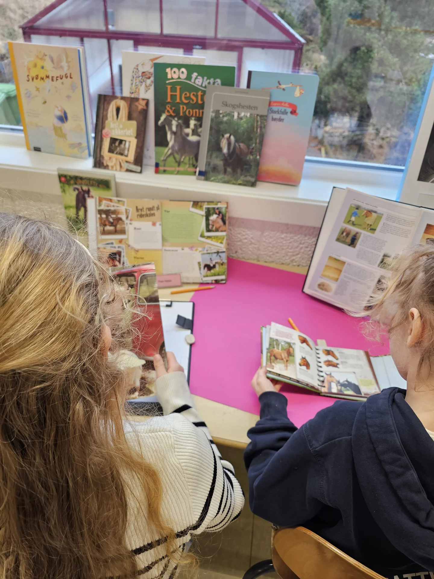 Elevar som utforskar bøker i biblioteket