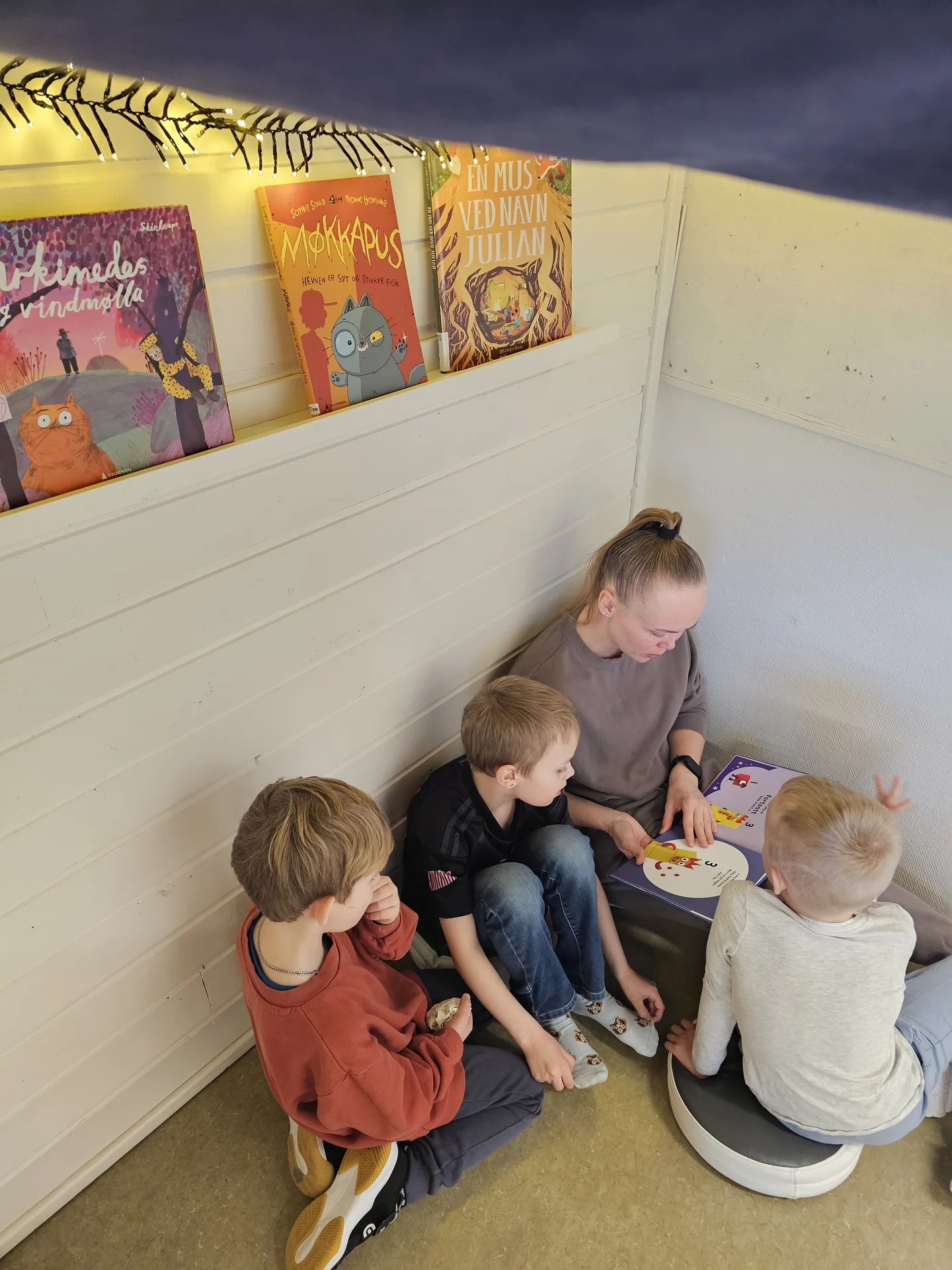 Vaksen som les bok for elevane